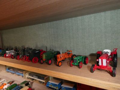 many toy trains on a shelf in a room