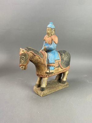 figurine représentant une femme à cheval, coiffée d'un chapeau bleu