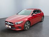 a red mercedes cla parked in a white room