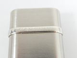 an image of a silver lighter sitting on top of a white table