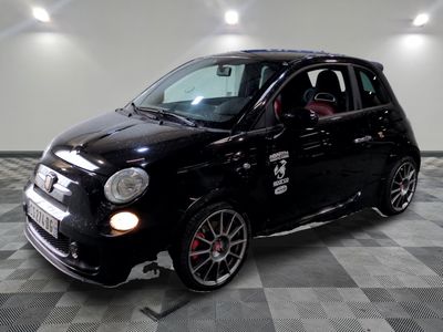la photo d'une petite voiture noire sur un sol en damier