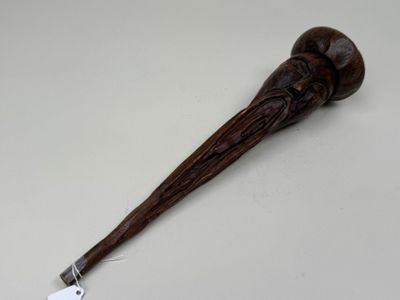 an image of a wooden stick with a handle and a tag on it