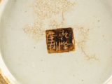 a white and gold plate with writing on it