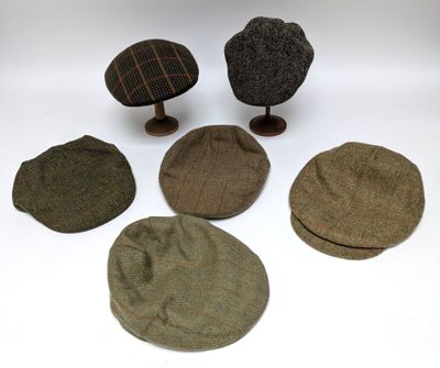 plusieurs chapeaux sont alignés les uns sur les autres sur une surface blanche