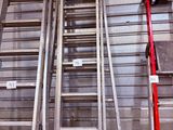 Plusieurs échelles sont alignées contre le mur d'un immeuble