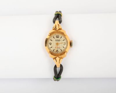un gros plan d'une montre-bracelet posée sur une serviette blanche