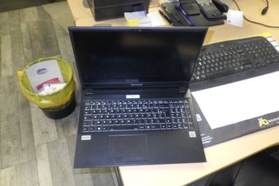 un ordinateur portable posé sur un bureau, à côté d'un clavier