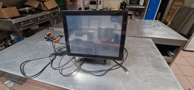 a computer monitor sitting on a table in a kitchen