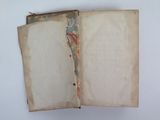 an open book with a torn page on top of it on a white surface