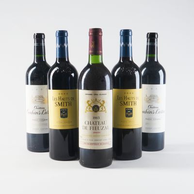 quatre bouteilles de vin sont alignées sur une surface blanche