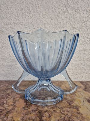 une photo d'un bol en verre bleu posé sur une table en marbre
