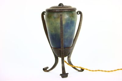 a blue and green vase on a stand with a yellow cord
