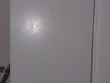 a white refrigerator in the corner of a kitchen