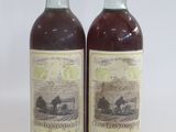 two bottles of wine sitting next to each other on a white surface