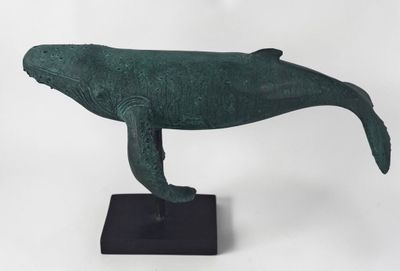 bronze sculpture of a humpback whale on a black base