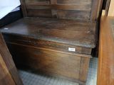 a wooden bench with a wooden seat in the corner of a room