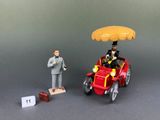 a figurine of a man riding in a car with an umbrella on top of it
