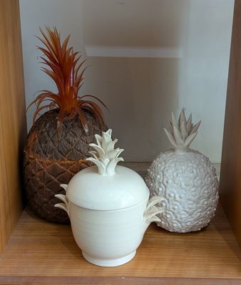 a shelf with a pineapple and a potted plant on it