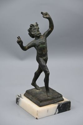 statue en bronze représentant un garçon sur un socle en marbre, la main levée