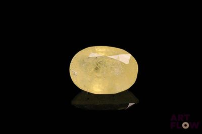un diamant jaune sur une surface noire