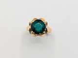a close up of a ring with a green stone in it