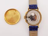 an image of a watch and a gold plate on a white surface