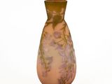 un vase en verre orné de fleurs, posé sur une surface blanche