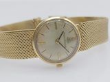 a close up of a gold wrist watch on a white surface