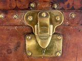 a small wooden trunk with a brass lock on it