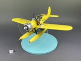 yellow model airplane with a man sitting on top of it on a blue base