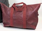 leather duffel bag with zippers and handles on a white surface