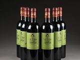 four bottles of red wine are lined up in a row