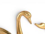 a gold swan figurine sitting next to a gold vase