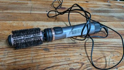 un sèche-cheveux et une brosse posés sur une table en bois