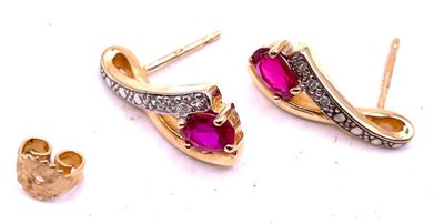 une paire de boucles d'oreilles en rubis et diamants sur fond blanc