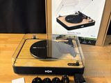 un tourne-disque posé sur une table en bois, à côté d'une boîte