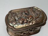 a silver box with a bird and flowers design on it