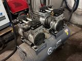 un petit compresseur d'air posé sur un chariot dans un garage