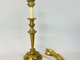 a brass plated candle holder with a white candle on top of it