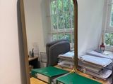 un bureau avec un miroir et une chaise devant une fenêtre