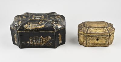 deux boîtes noires et dorées posées l'une à côté de l'autre sur une surface blanche