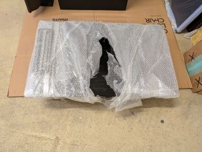 une boîte contenant une paire de chaussures, posée par terre