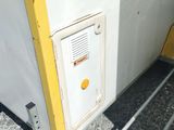 a yellow door on the side of a white wall