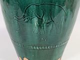a green vase with a picture of an elephant on it