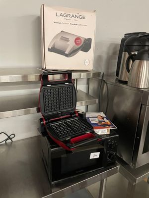 a laptop and a coffee maker sitting on a table