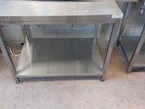 two stainless steel tables with a microwave sitting on top of them