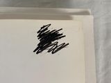 an open book with a black ink drawing of a tree on it