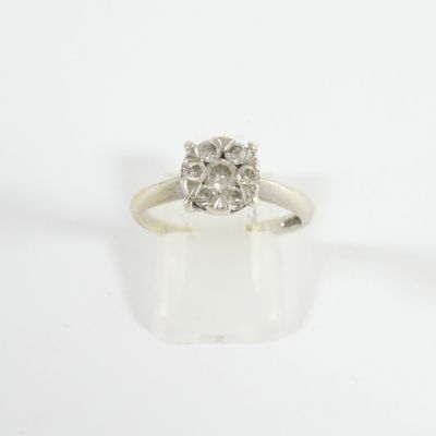 a close up of a diamond ring on a white surface
