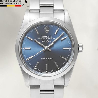 a silver watch with a blue dial on it