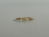 a close up of a diamond ring on a white surface